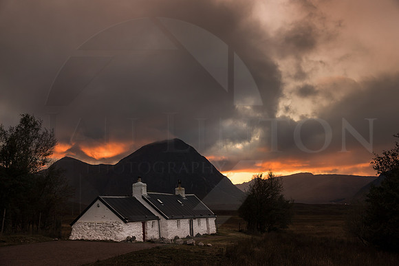Black Rock Cottage with a dramatic sky with Buachaille Etive Mòr as a backdrop